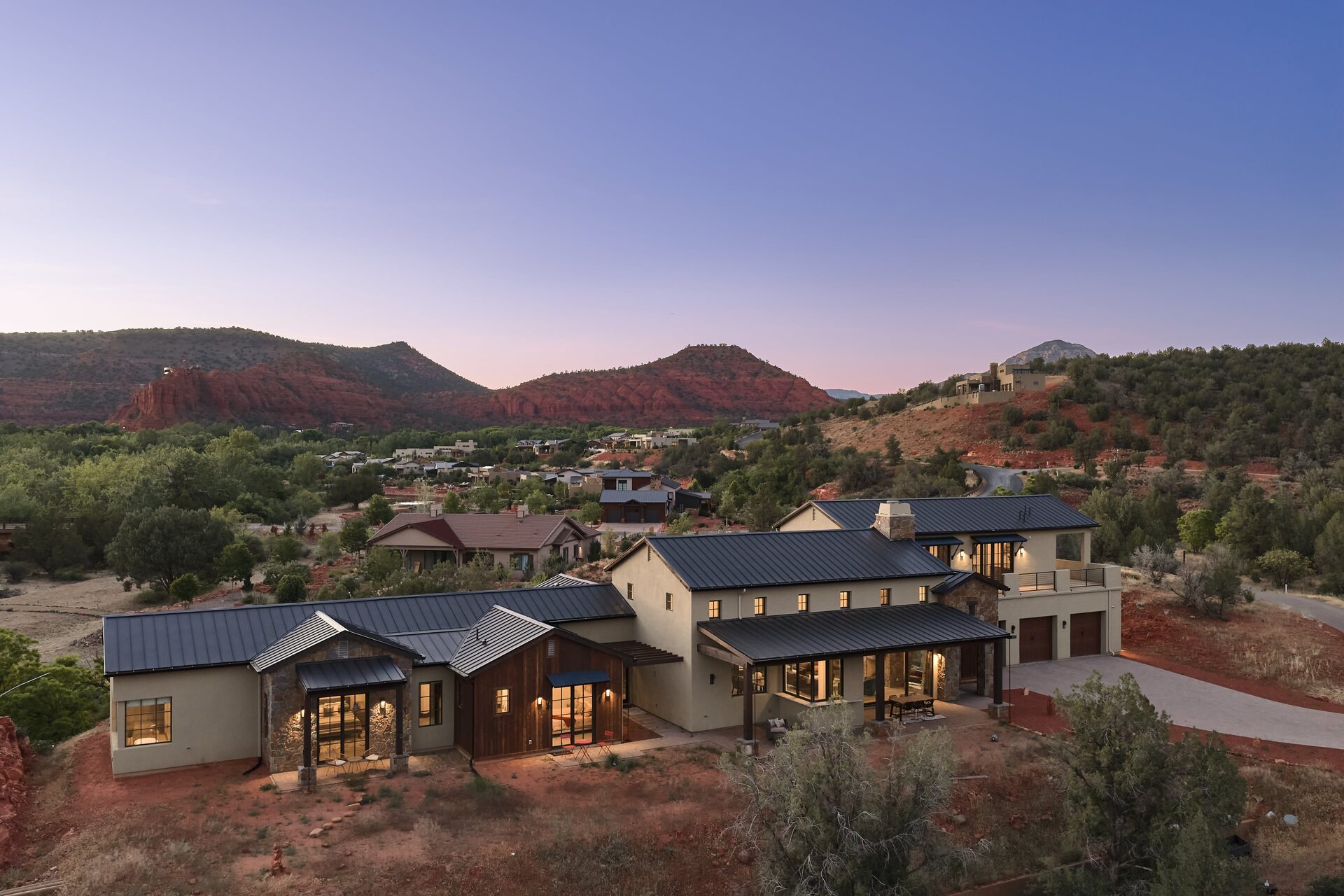 The estate at dusk against red rock backdrop