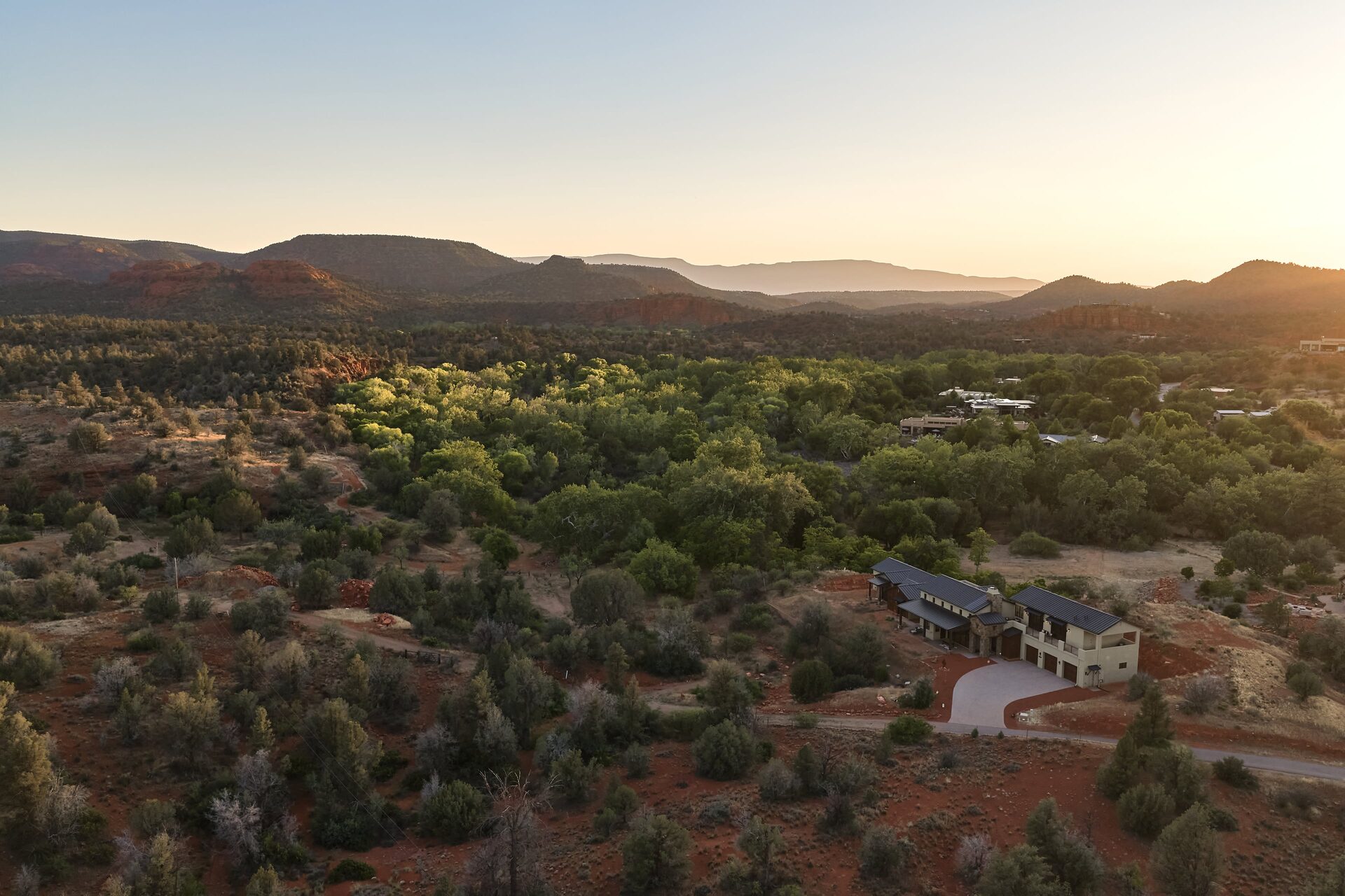 Aerial of the property and surrounding red rock landscape at golden hour